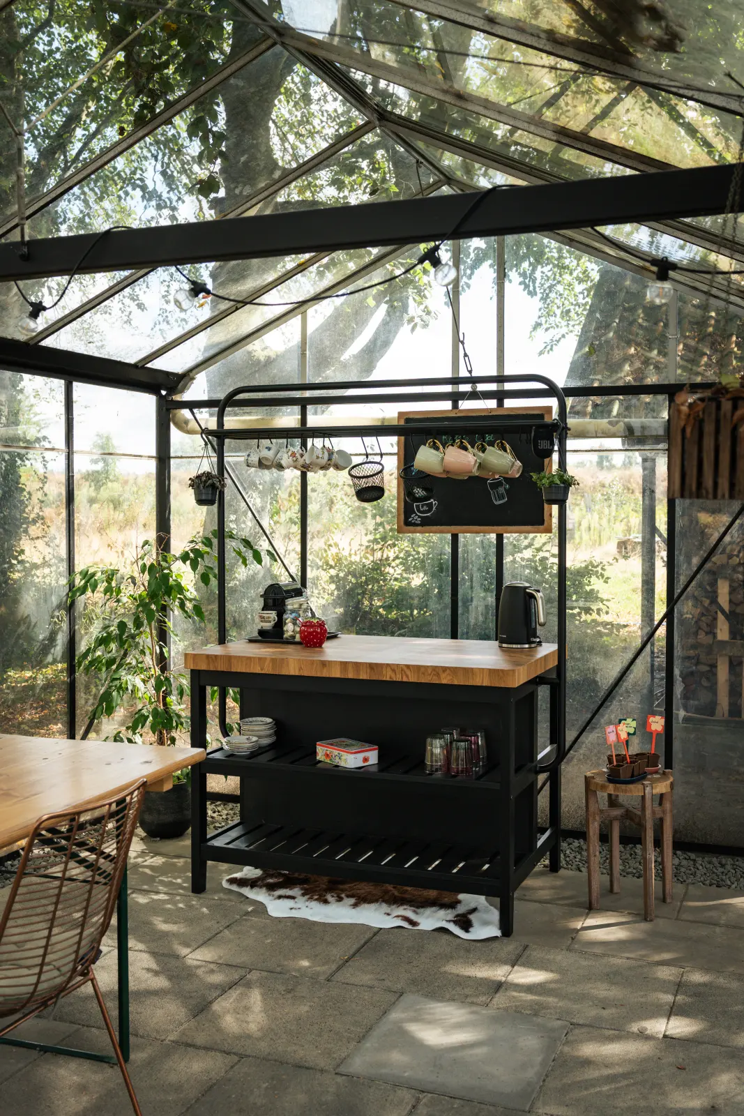 Glazen interieur van de kas met uitzicht op de groene heemtuin